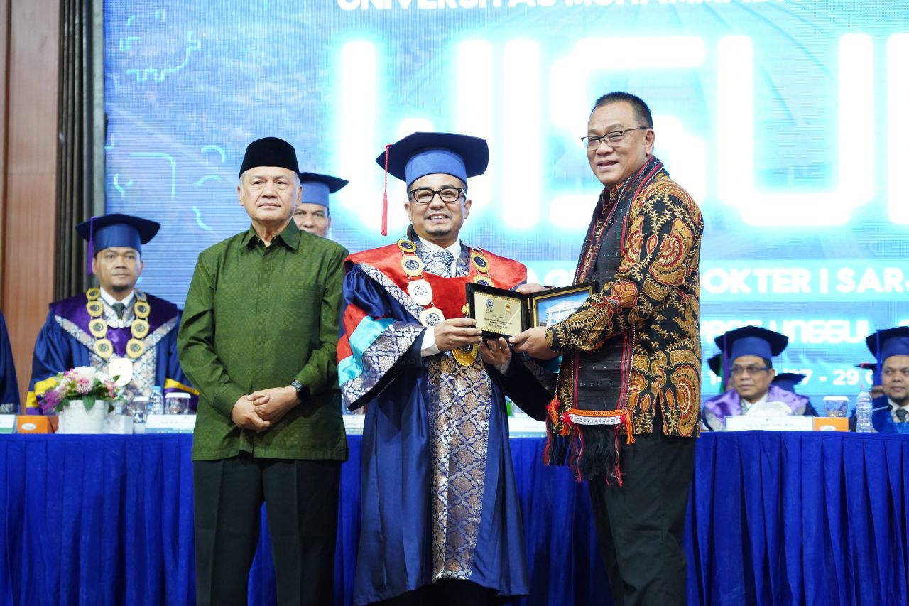 Rektor UMSU Prof. Dr. Akrim, M.Pd. menyerahkan cenderamata kepada Menteri LH Jumhur Hidayat pada hari pertama wisuda lulusan UMSU, Selasa (27/10/2026).