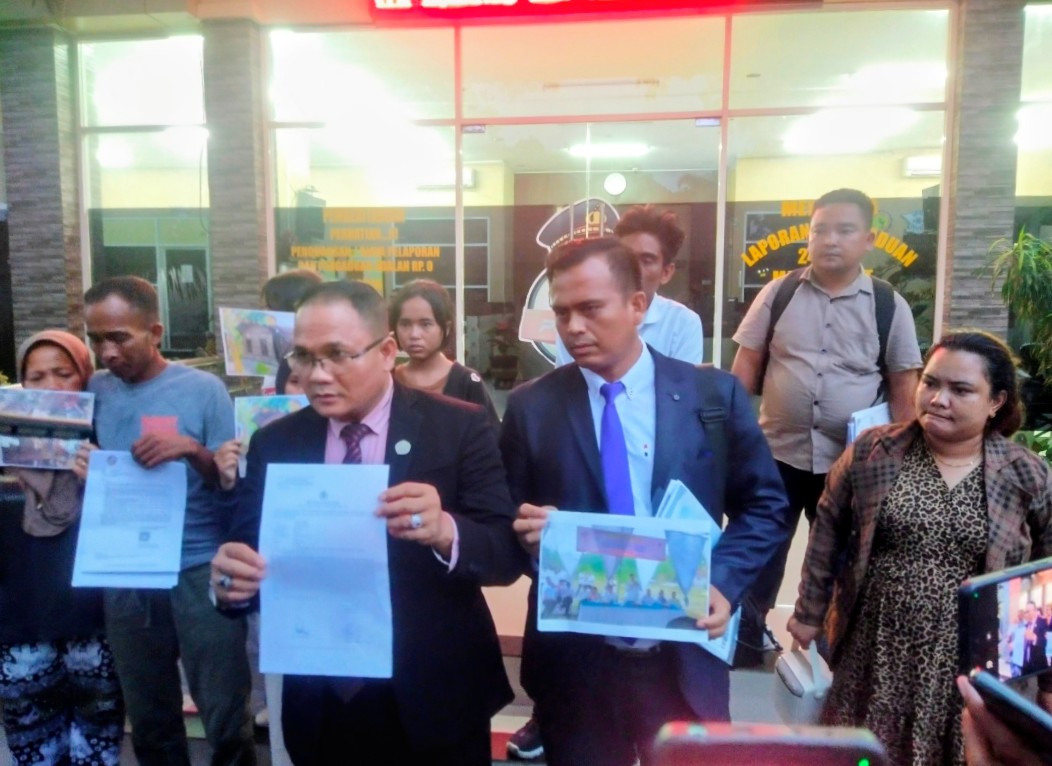 Tunjukkan Bukti Laporan: Advokat Dr. Ramces Pandiangan, S.H., M.H. bersama tim kuasa hukum dan warga korban pembongkaran memamerkan berkas Laporan Polisi (STTLP) serta foto-foto bukti pengerusakan rumah di depan SPKT Polda Sumatera Utara, Medan, Rabu (14/10/2026). (Foto: Istimewa)